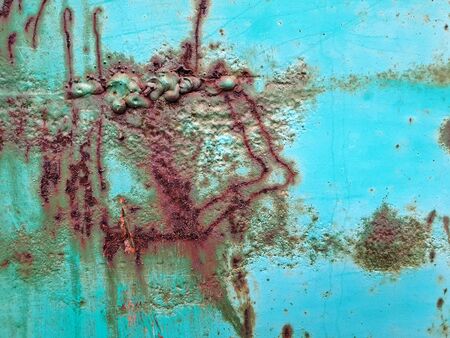 Close up photography of a weathered metal wall with rust and peeling paint..の写真素材
