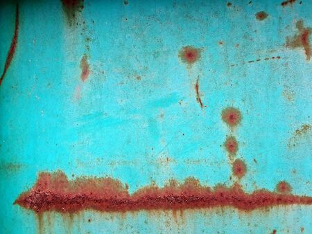 Close up photography of a weathered metal wall with rust and peeling paint..の写真素材