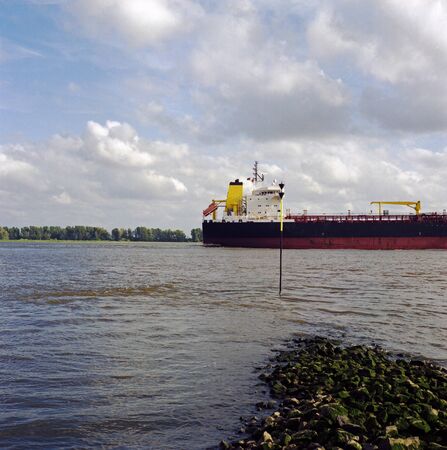 Color analog photography of a nautical vessel, passing by on a riverの写真素材