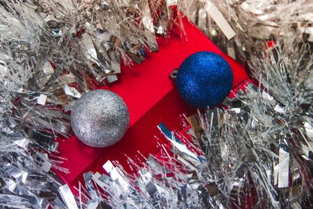 Red gift under silver tinsel with new year's toysの写真素材