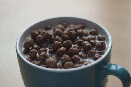 Chocolate cereals with milk in a big cup close upの写真素材