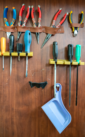 Tool plate with fixed tool. Screwdrivers and flat-nose pliers on the board.