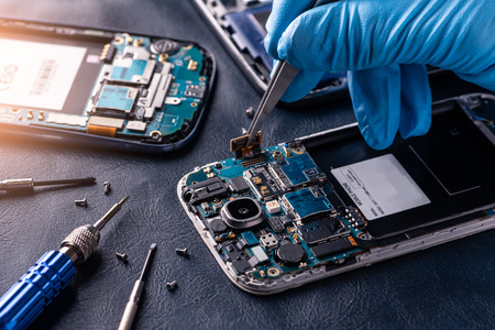 The asian technician repairing the smartphone's motherboard in the lab with copy space. the concept of computer hardware, mobile phone, electronic, repairing, upgrade and technology.の写真素材