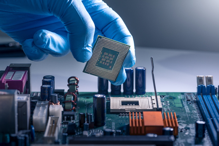 The technician is putting the CPU on the socket of the computer motherboard.の写真素材