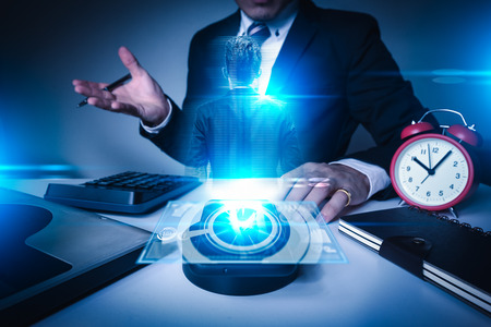 The abstract image of the businessman teleconferencing via a 3D virtual hologram in the office.の写真素材