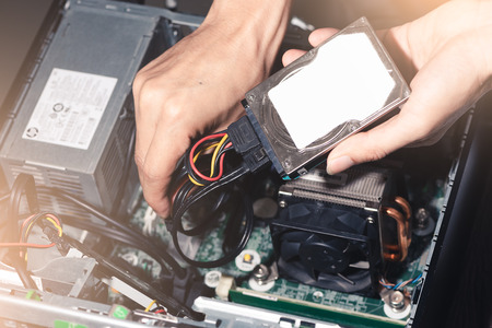 The abstract image of the technician put the Hard disk drive in the computer case. the concept of...
