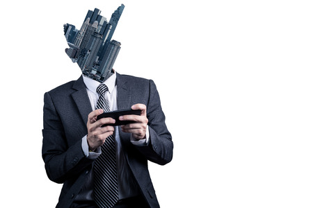 The double exposure image of the business man using a smartphone overlay with cityscape image. The...