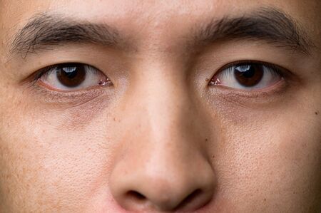 the close up image of the eyes of asian man. The concept of modern life, technology, iris scanner and internet of thingsの写真素材
