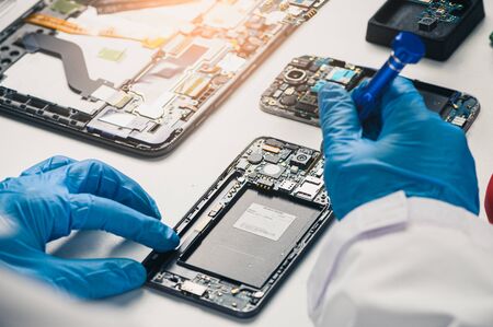 The asian technician repairing the smartphone's motherboard in the lab with copy space. the concept...