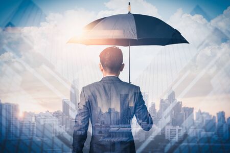 The double exposure image of the Businessmen are spreading umbrella during sunrise overlay with cityscape image. The concept of modern life, business, insurance and protection.の写真素材