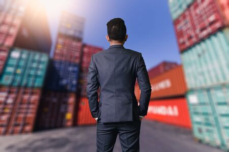 The abstract image of engineer standing in the container yard during sunrise. the concept of...