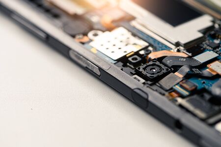 The abstract image of the technician assembling inside of smartphone by screwdriver in the lab. the...