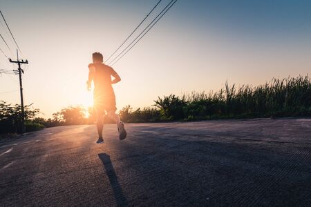 the abstract image of the runner running on the countryside road in the morning. the concept of healthy, running, energy and future.の写真素材