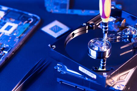 The abstract image of inside of hard disk drive on the technician's desk and a computer motherboard as a component. the concept of data, hardware, and information technology.の写真素材