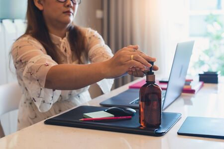 the abstract image of the woman washing his hand by the alcohol gel. the concept of covit-19, work at home, quarantine, healthcare and business.の写真素材