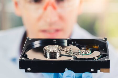 The abstract image of the technician is analysing the inside of hard disk drive. the concept of...