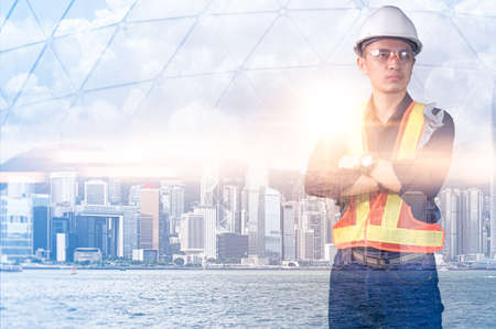 The double exposure image of the engineer standing back during sunrise overlay with cityscape image. The concept of engineering, construction, city life and future.の写真素材