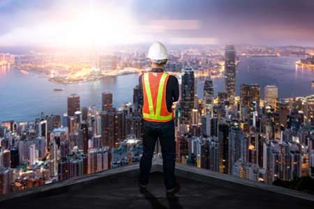 The double exposure image of the engineer standing back during sunrise overlay with cityscape image. The concept of engineering, construction, city life and future.の写真素材