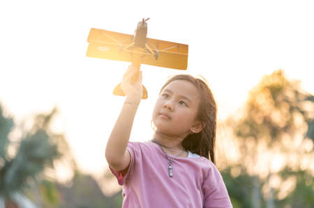 the kids playing the airplane toy in the park during sunrise.の写真素材