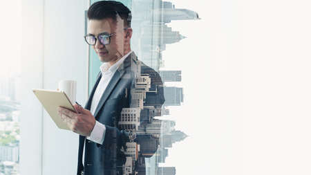 The double exposure image of the businessman standing back during sunrise overlay with cityscape...