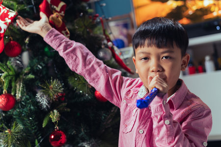 the children playing around the Christmas tree during christmas eve night. the concept of festival, Christmas, new year, celebration and joyfulの写真素材