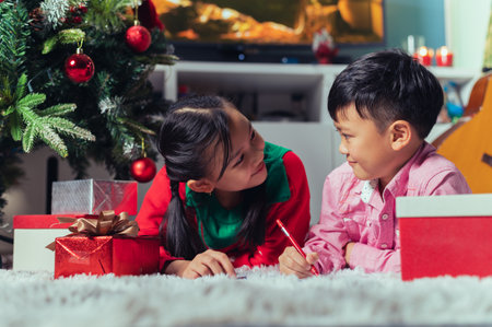 the children playing around the Christmas tree during christmas eve night. the concept of festival, Christmas, new year, celebration and joyfulの写真素材