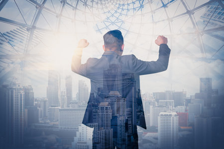 The double exposure image of the business man standing back during sunrise overlay with cityscape image. The concept of modern life, business, city life and internet of things.の写真素材