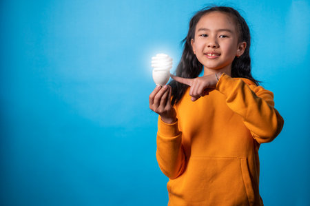 the studio isolated the image of the girl holding the lamp and get the idea with a blue backdropの写真素材