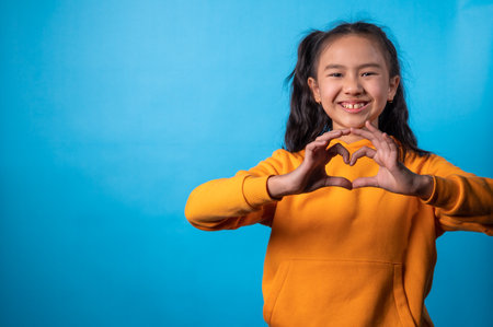 the studio portrait image of the girl showing heart symbol by handsの写真素材