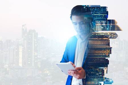 The businessman is depicted through a mesmerizing double exposure technique, where his silhouette intertwines with various urban landscapes or business-related imagery.の写真素材