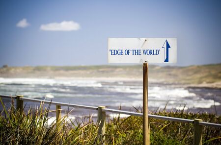 A sign saying Edge of the World points out to seaの写真素材