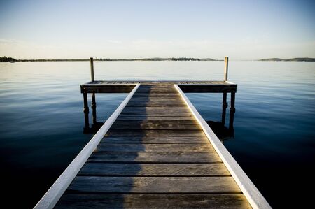 Wooden pier / jetty stretches out into an idyllic oceanの写真素材