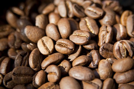 Background of rich, dark coffee beans in a pileの写真素材
