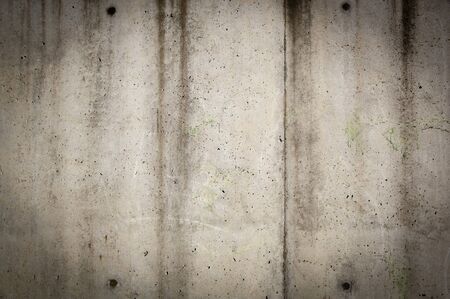 Tall concrete wall in rough, gunge style with stains and wearの写真素材