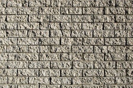 Grunge style brick wall with rough bricks in sunlightの写真素材