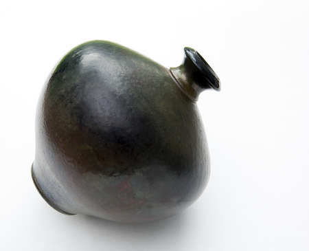 An older style round vase in dark shades on whiteの写真素材