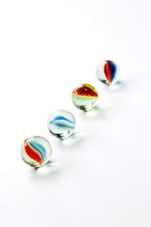Brightly colored marbles in different shades on bright whiteの写真素材