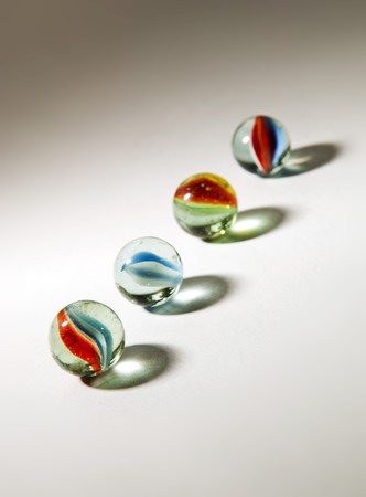 Brightly colored marbles in different shades with deliberately long shadowsの写真素材