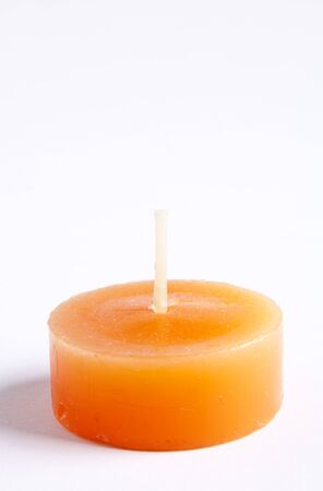 Tealight candles in bright orange against a plain backgroundの写真素材