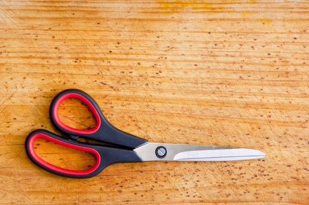 Modern scissors sit atop a wooden boardの写真素材