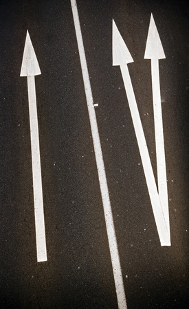 Large painted arrows on a freeway contrast with the bitumenの写真素材