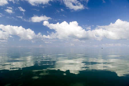 Large white clouds gleam over deep waters