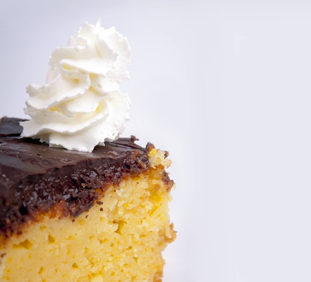 An orange cake with chocolate icing and whipped creamの写真素材