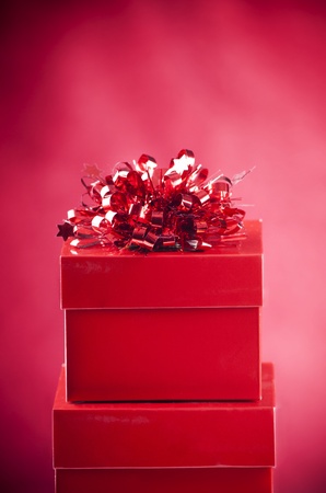 Bright red gift boxes with decoration on a blurred red backgroundの写真素材