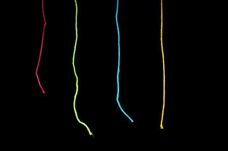 Sting in various bright colours over blackの写真素材