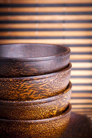 Handmade wooden bowls on a bamboo matの写真素材