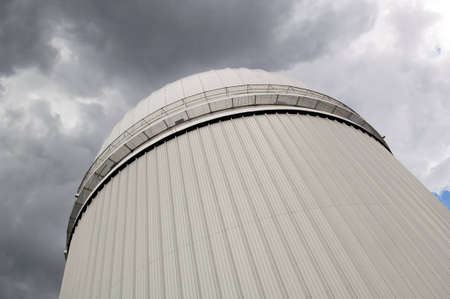 Astronomical observatory from below with moody skyの写真素材