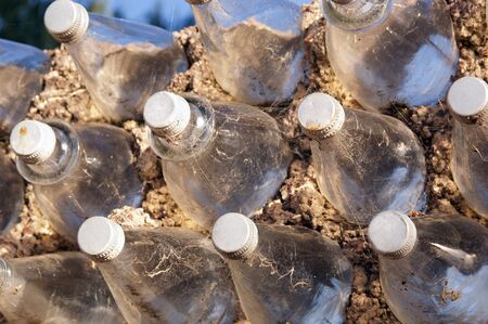 Old glass bottles used to build a wall as a background textureの写真素材