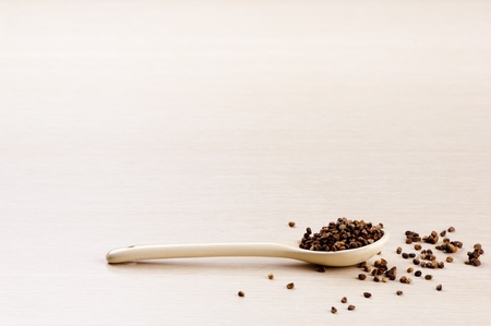 Cardamom Seeds in a spoon with some spilt over the wooden backgroundの写真素材