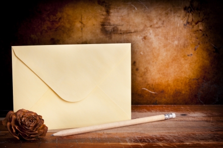 Vintage envelope background with pencil on a dark grunge background in shallow focusの写真素材